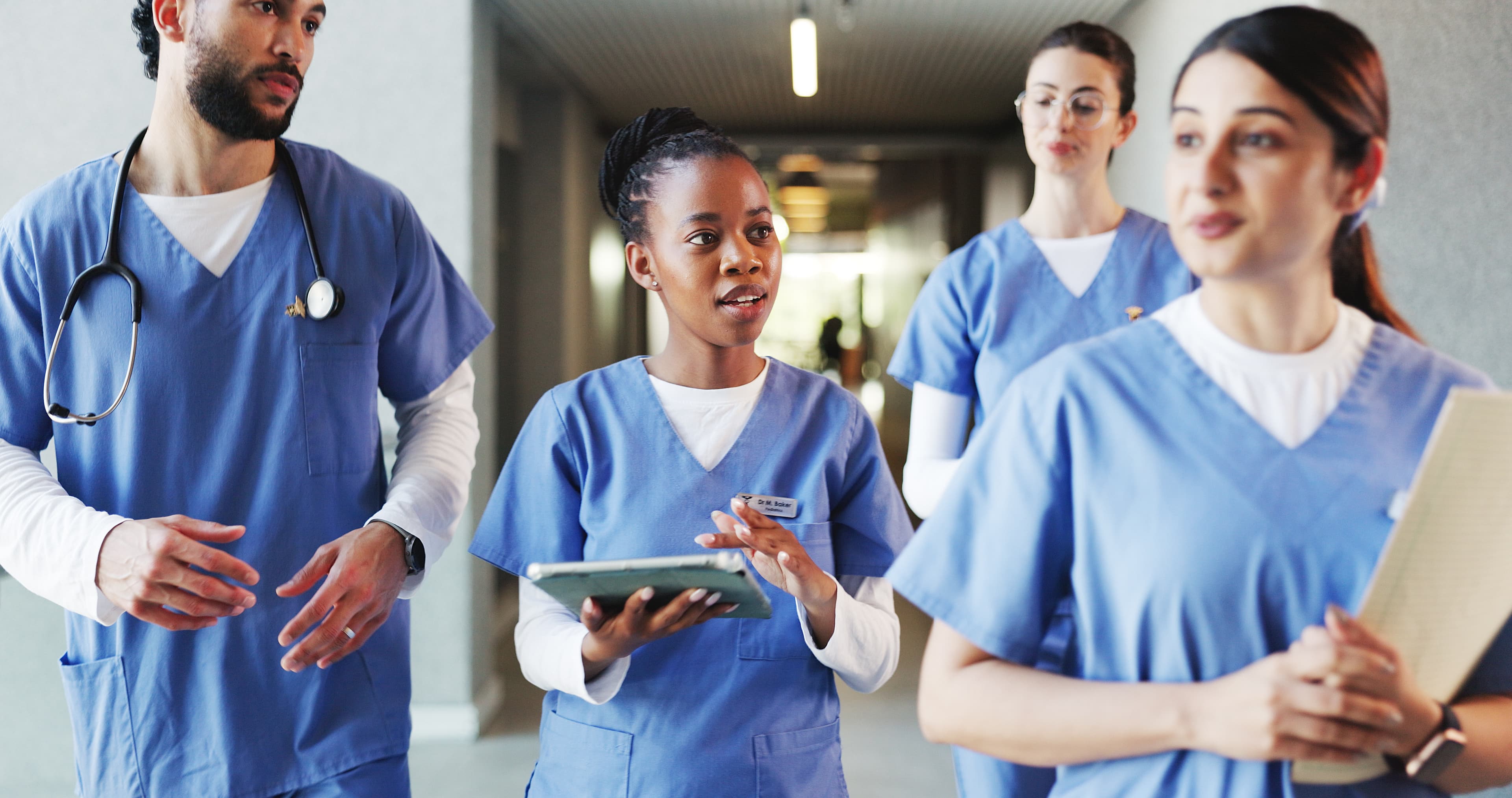 PMHS Certification Exam Preparation PMHS (Pediatric Primary Care Mental Health Specialist) exam prep - clinicians and students reviewing a tablet in a hospital lobby | Psychiatric Mental Health Review